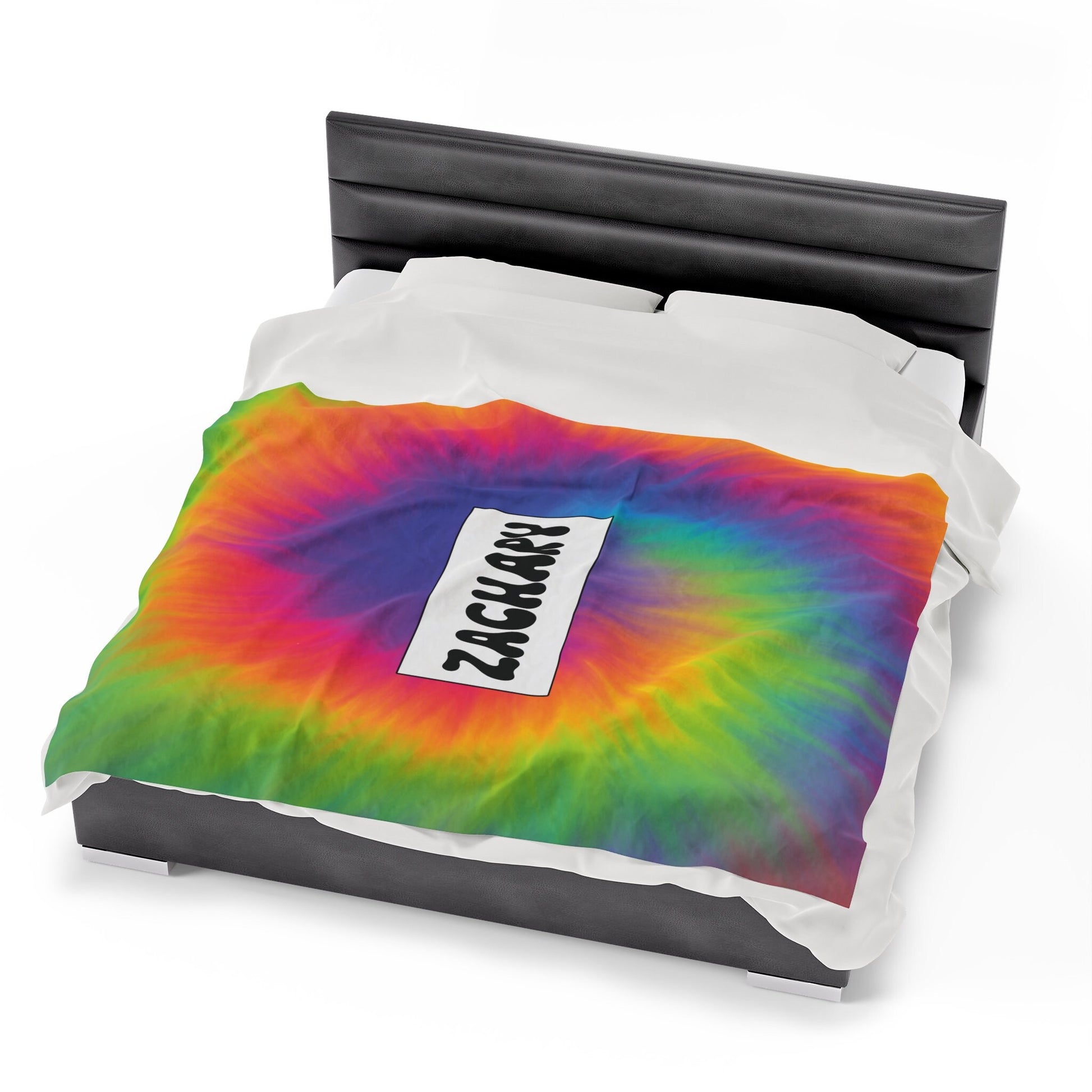 a bed with a rainbow colored comforter and pillow
