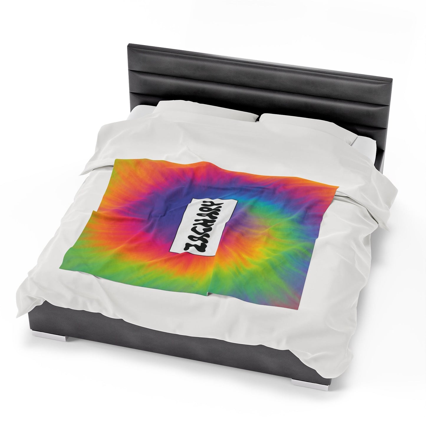 a bed with a tie dye comforter on it
