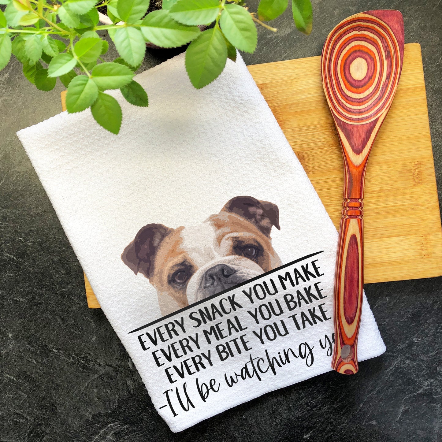 a brown and white dog sitting on top of a wooden cutting board next to a