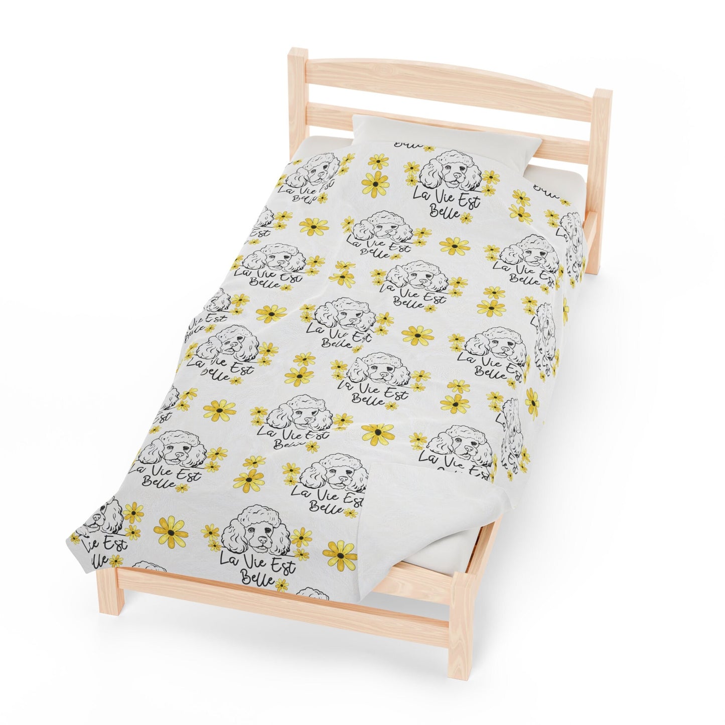 a bed with a white sheet with yellow flowers on it
