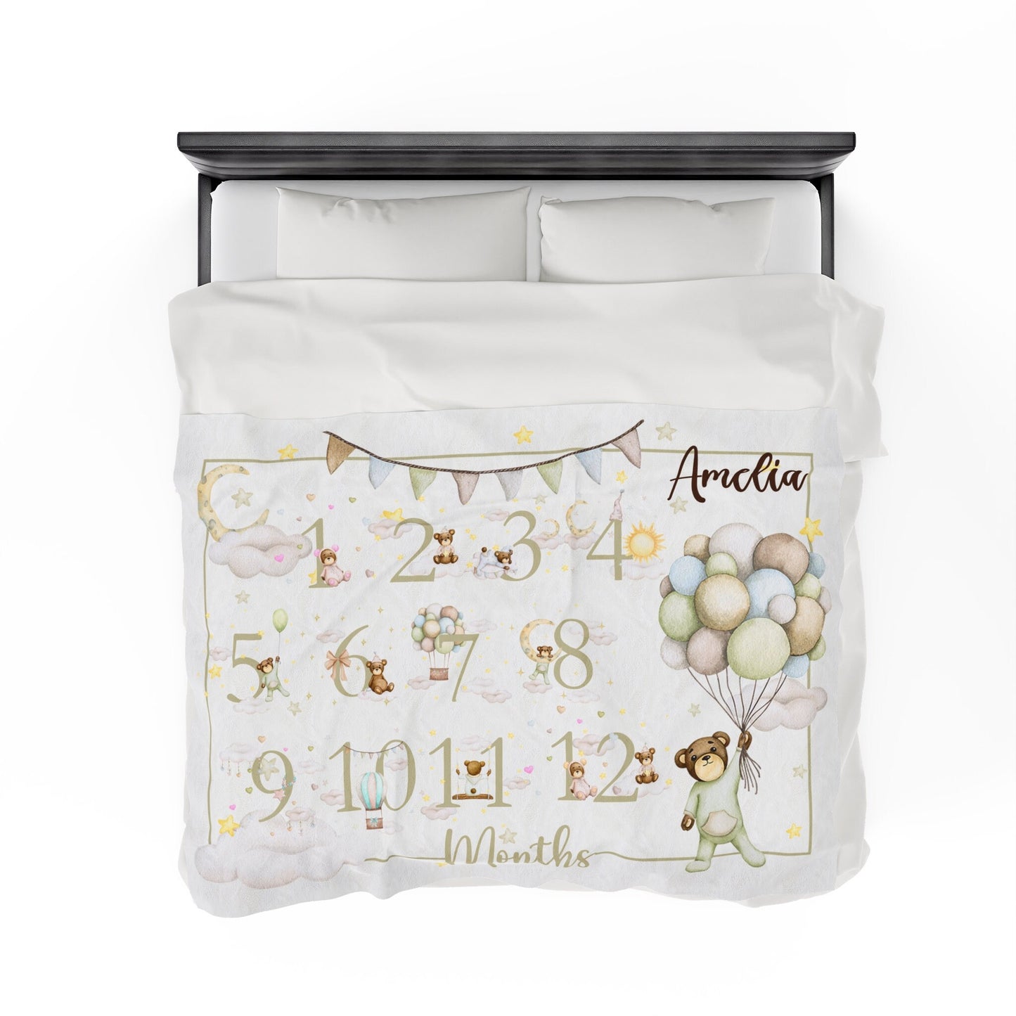 a white bed with a teddy bear and balloons on it