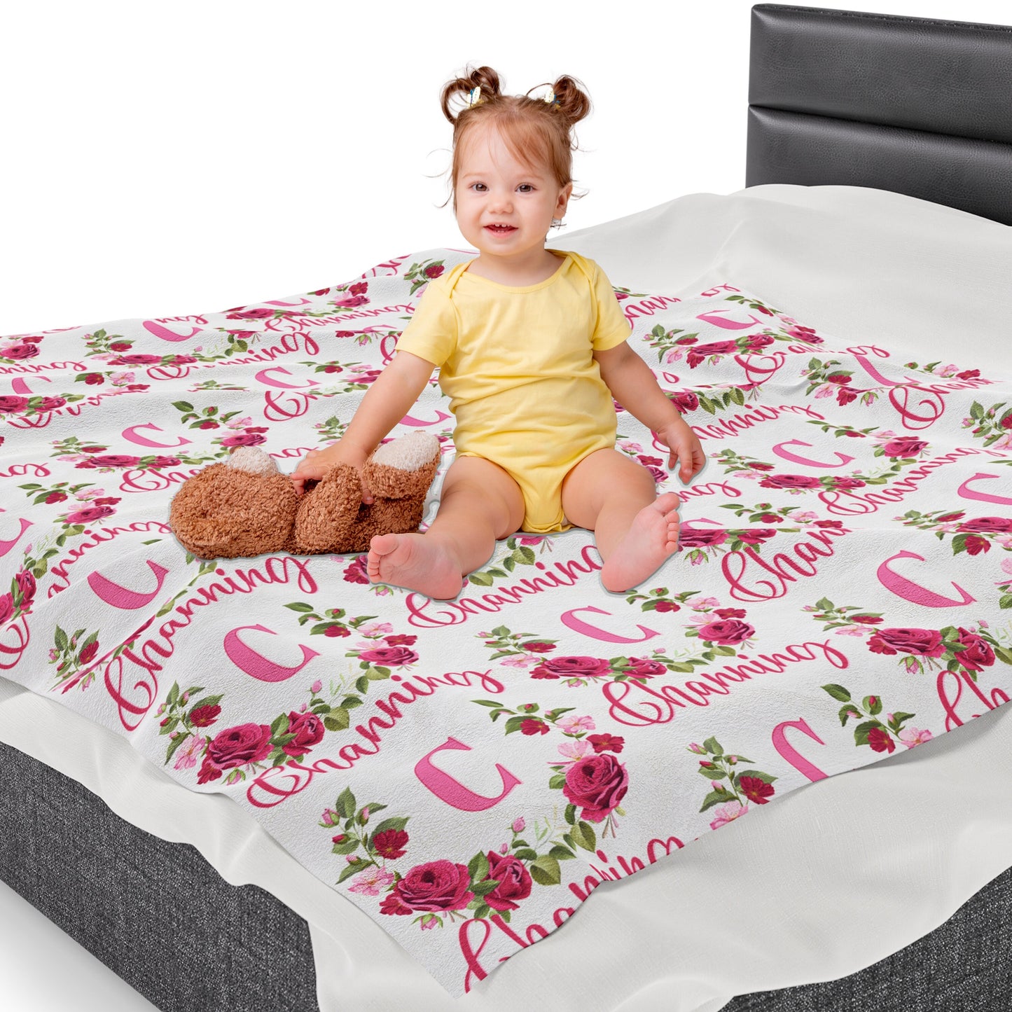 a little girl sitting on a bed with a teddy bear