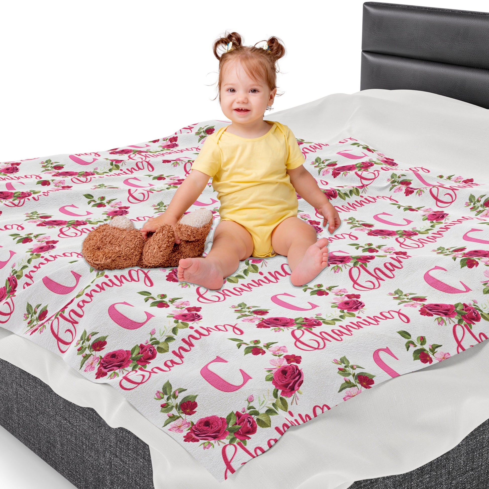 a little girl sitting on a bed with a teddy bear