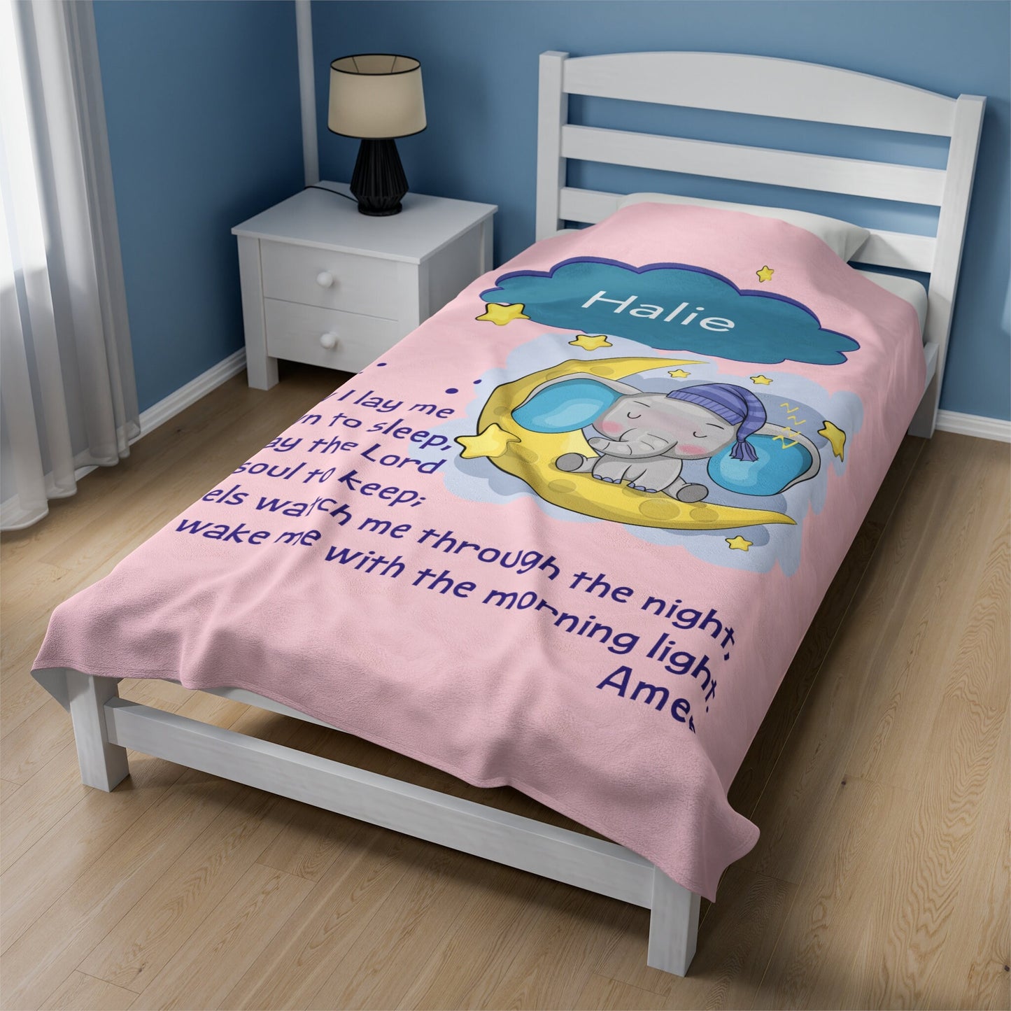 a child's bed with a pink comforter with an elephant on it