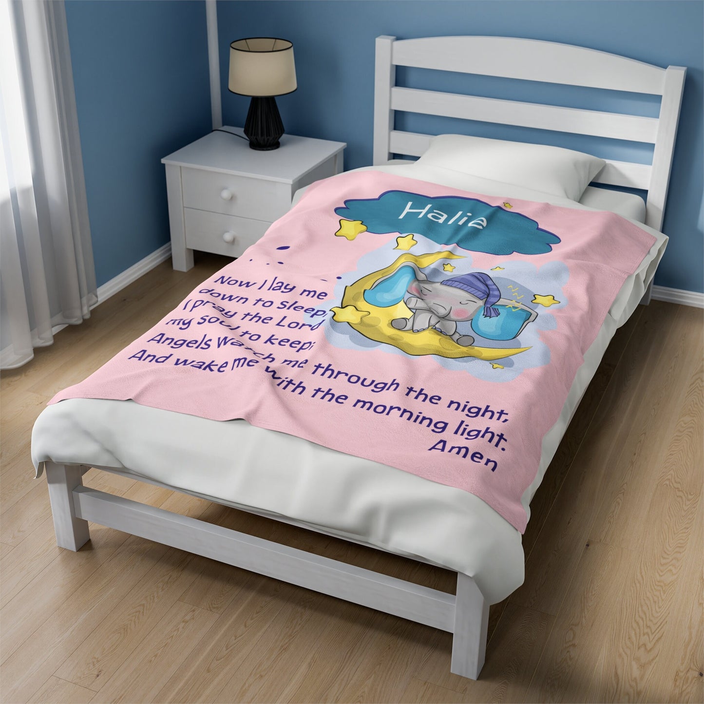 a child's bed with a pink comforter with a picture of an elephant