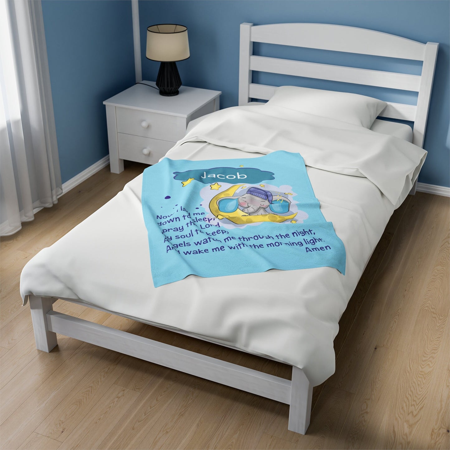 a bed with a blue comforter and a white night stand