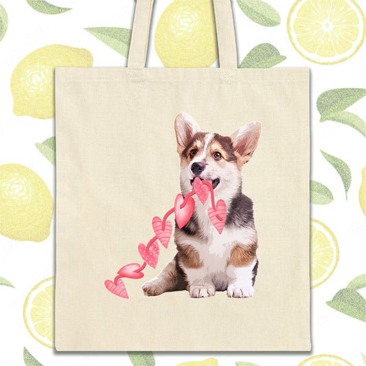 a tote bag with a picture of a corgi holding a ribbon