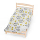 a single bed with a white sheet with yellow flowers on it