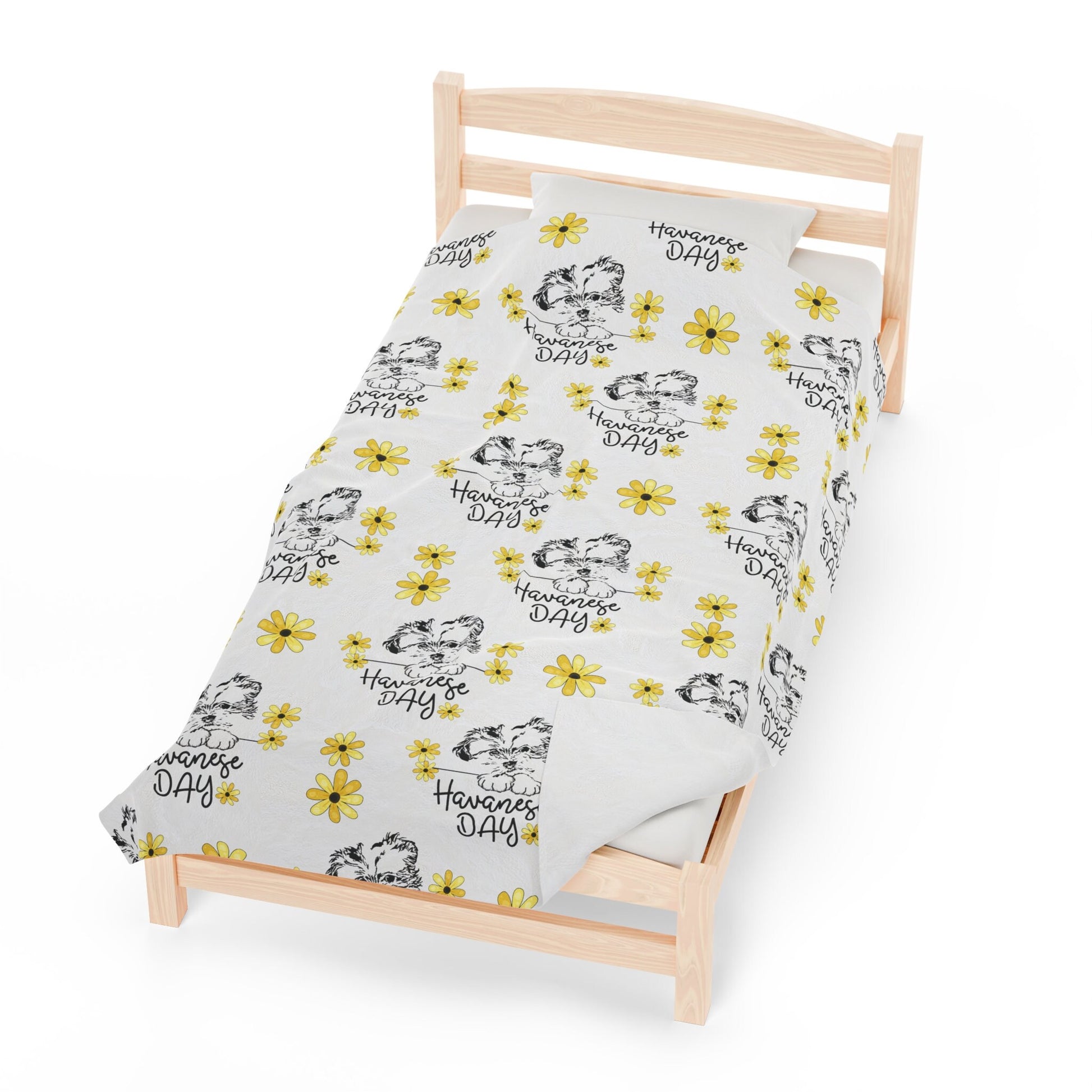 a single bed with a white sheet with yellow flowers on it