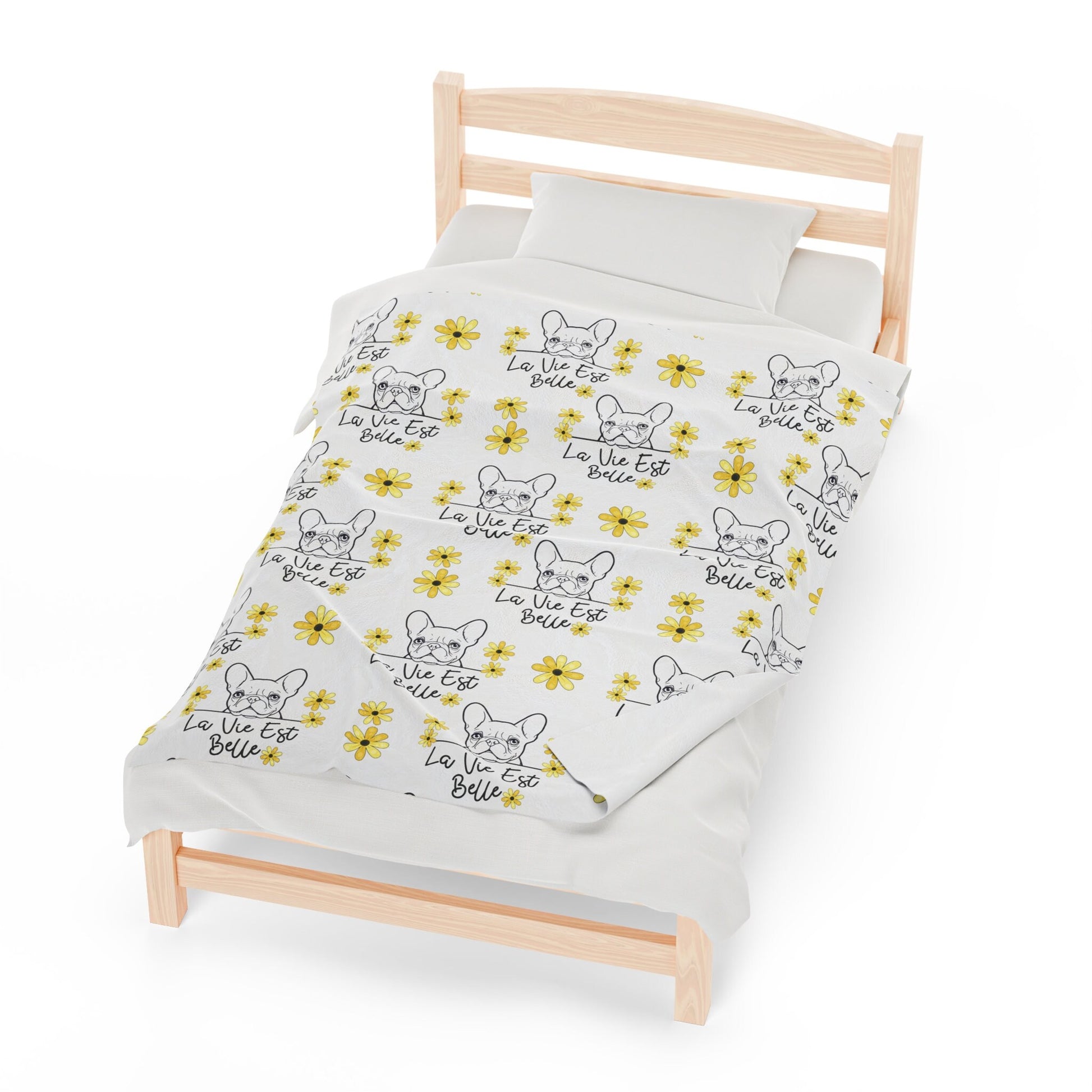 a bed with a white sheet with yellow flowers on it