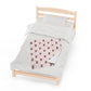 a bed with a white comforter and a pink and brown quilt