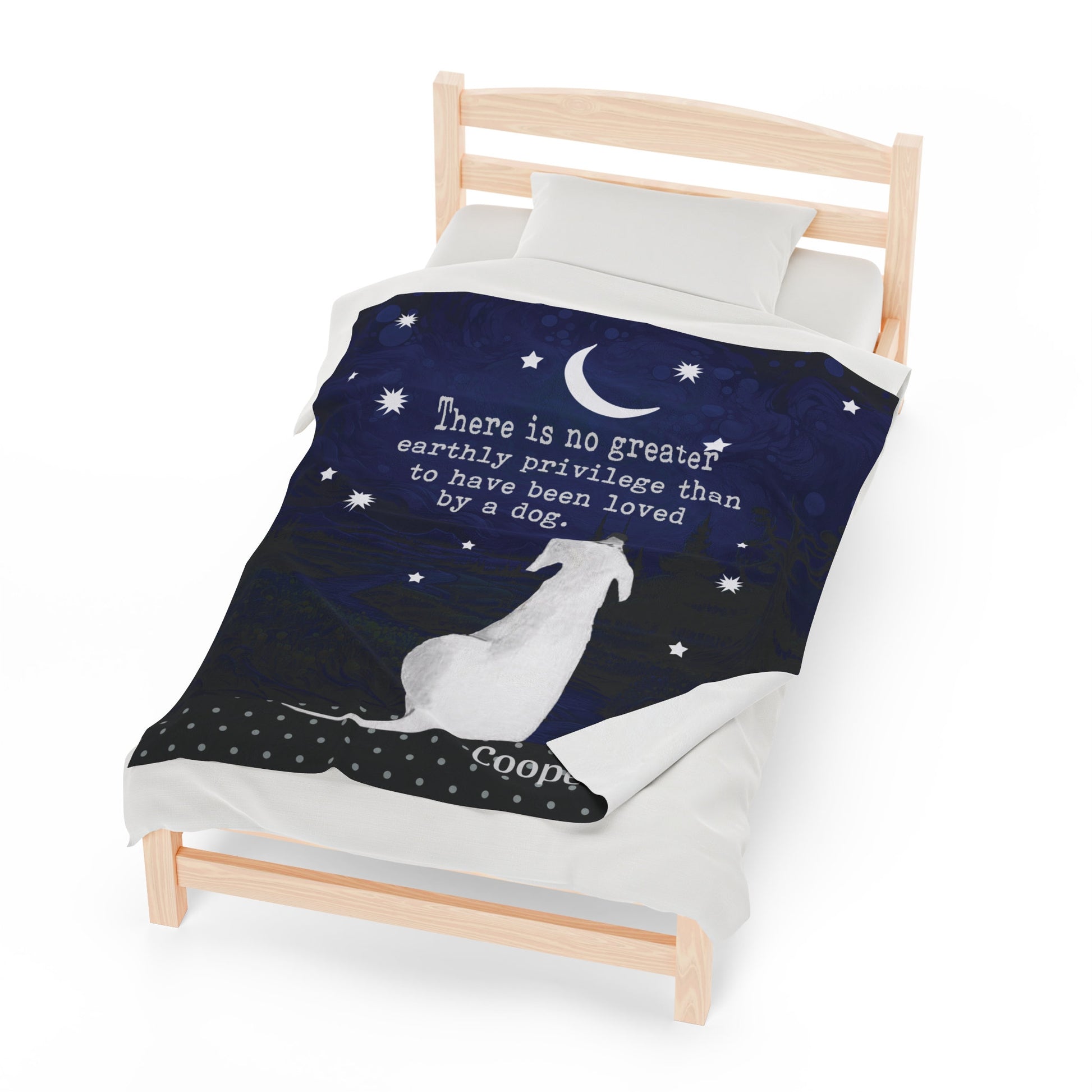 a bed with a blanket that has a picture of a dog on it