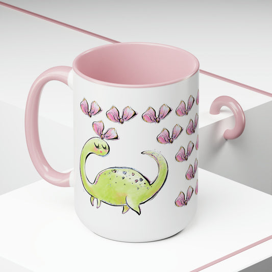 a pink and white mug with a green dinosaur on it