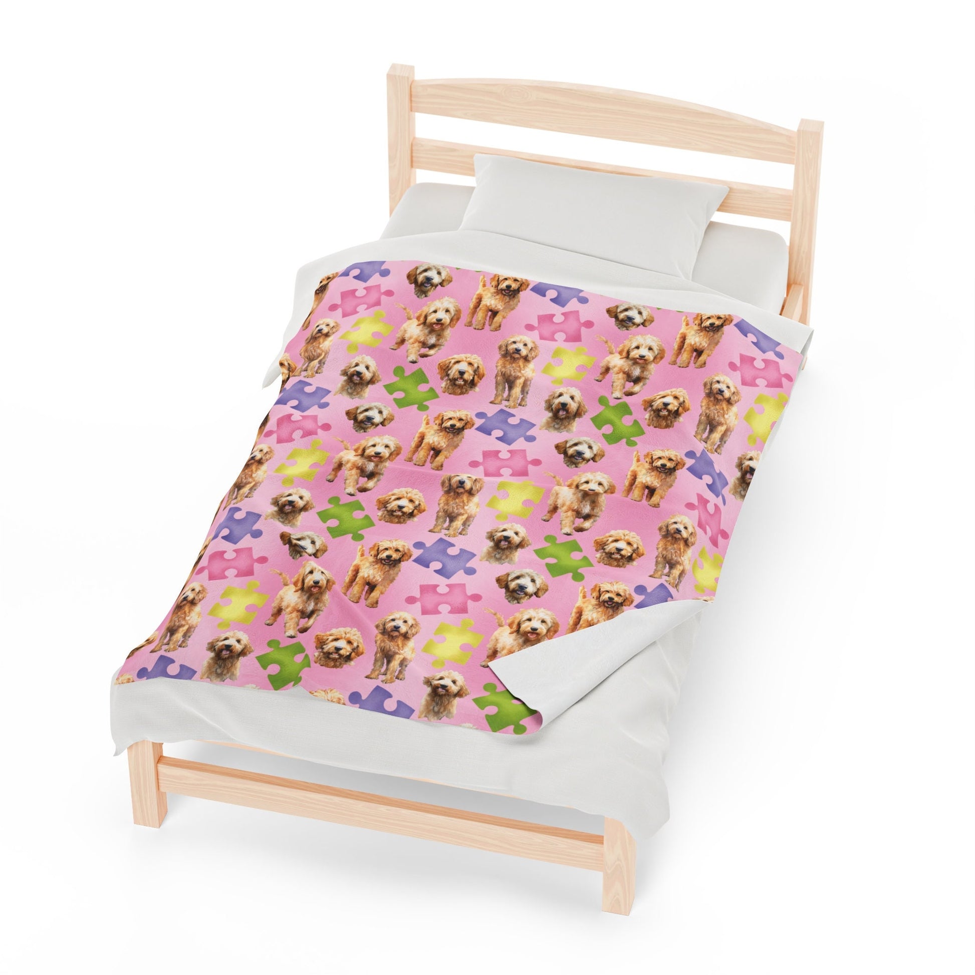 a bed with a pink blanket with dogs on it