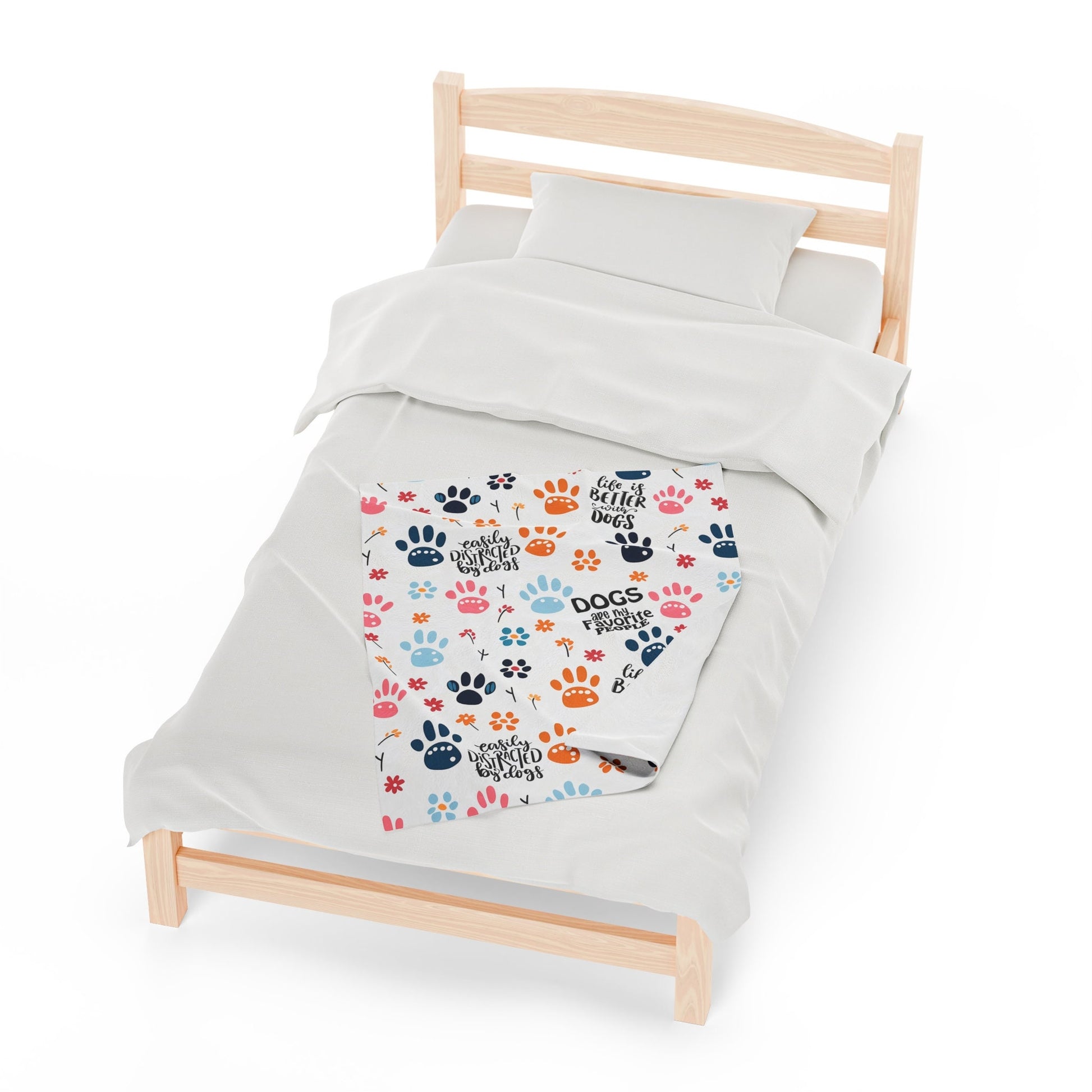 a bed with a white comforter and paw prints on it