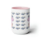 a pink and white coffee mug with a pattern of books on it