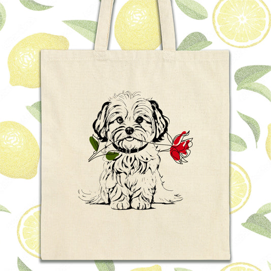 a dog with a rose in its mouth on a tote bag