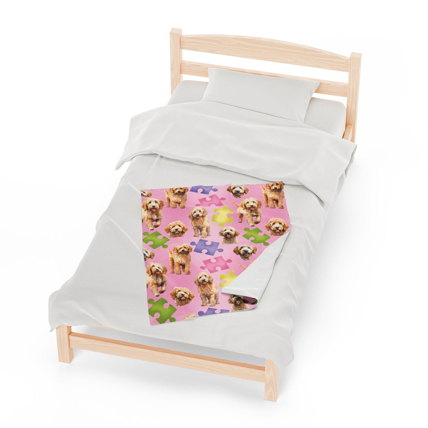 a bed with a pink blanket with dogs on it
